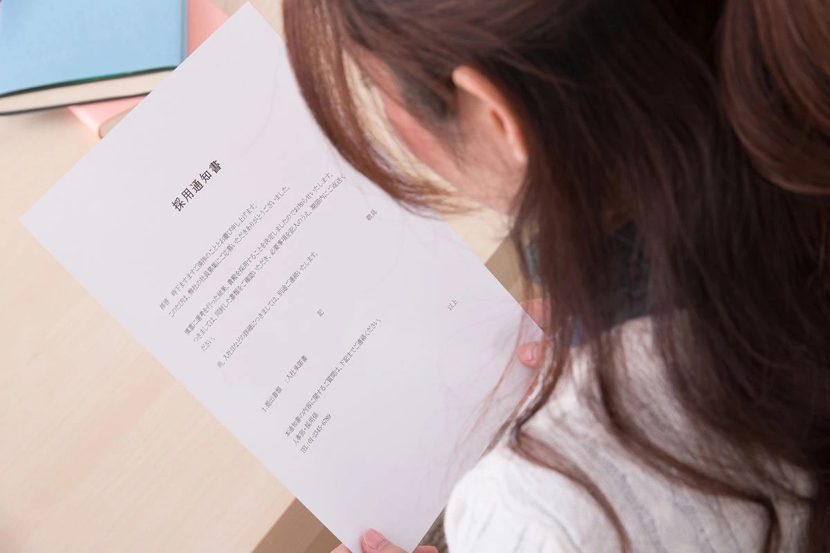 採用通知書を見る女性のイメージ