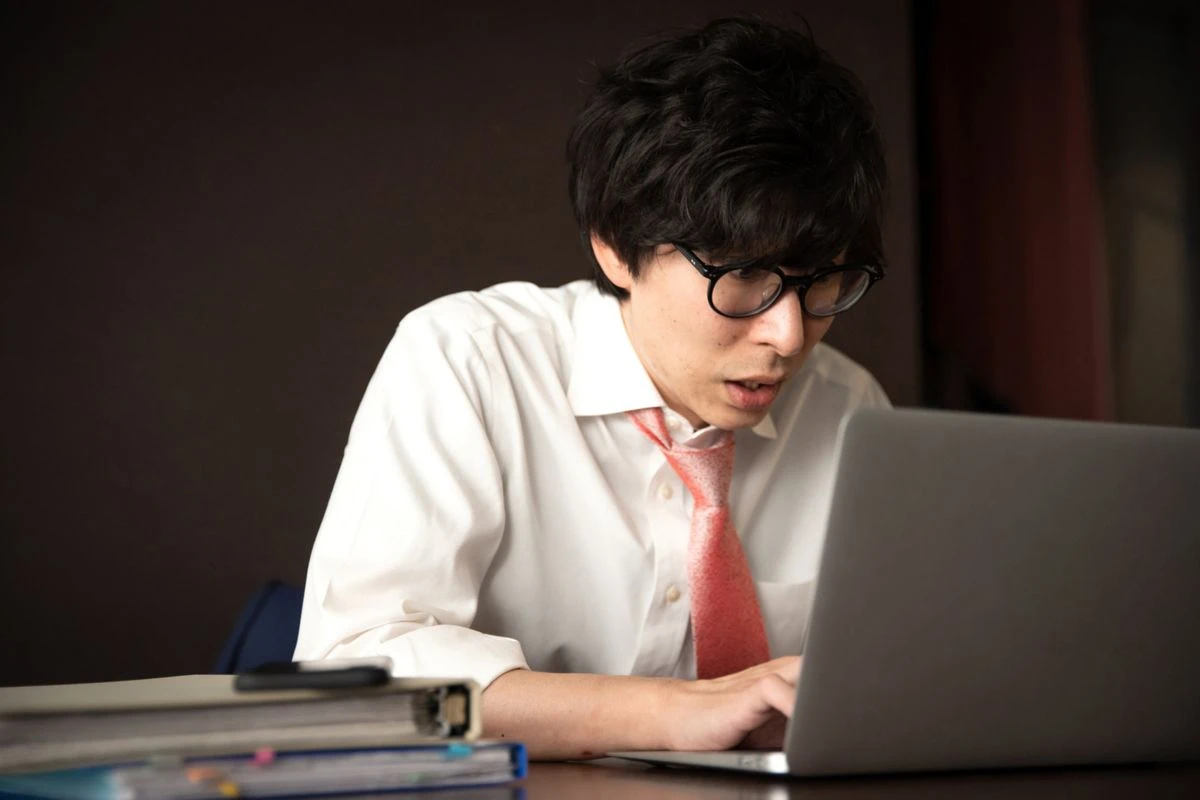 焦った表情でPCを見る男性のイメージ