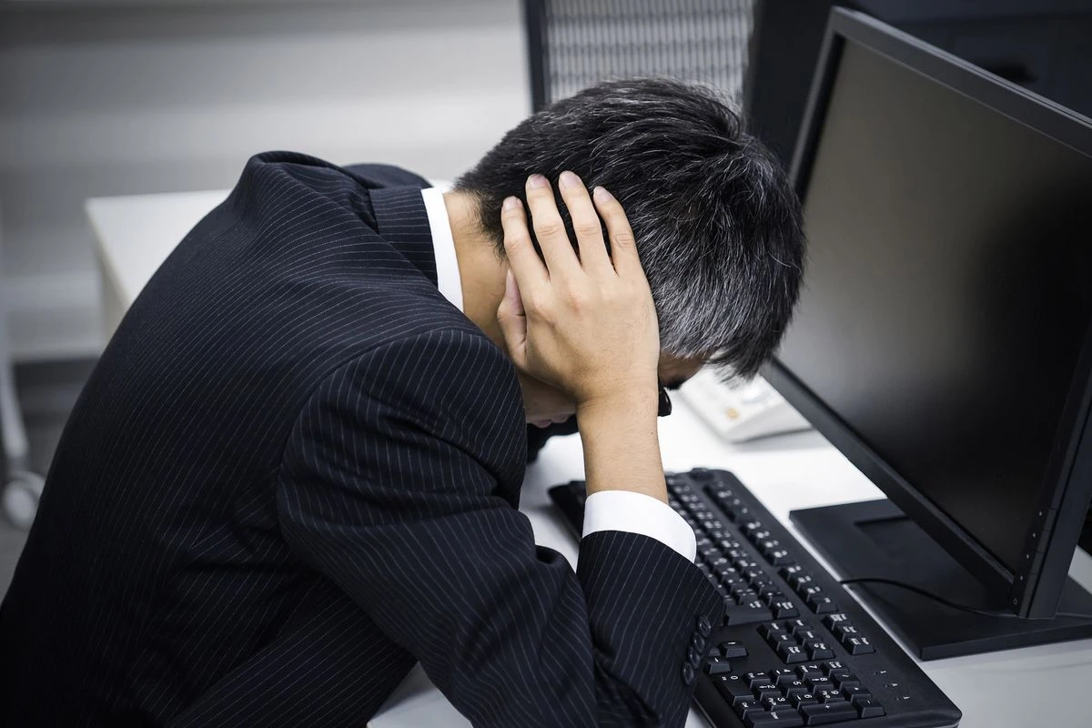 頭を抱える男性のイメージ