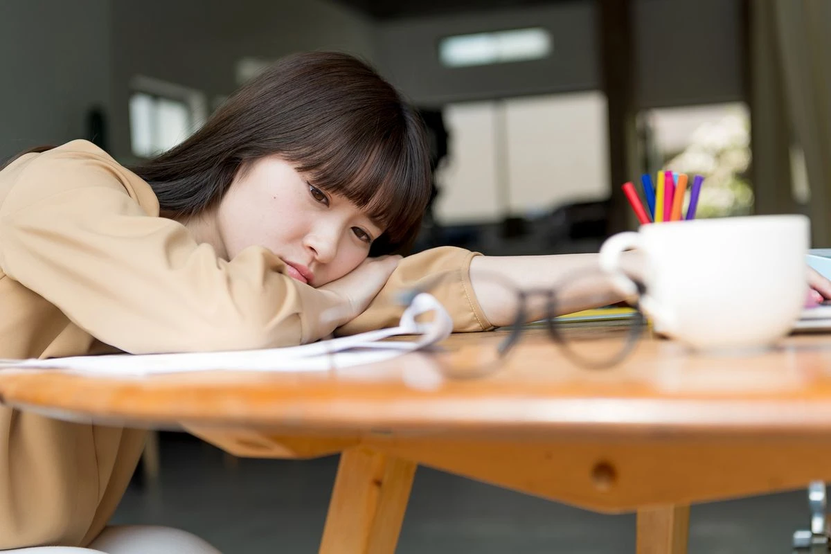 机に伏せる女性のイメージ