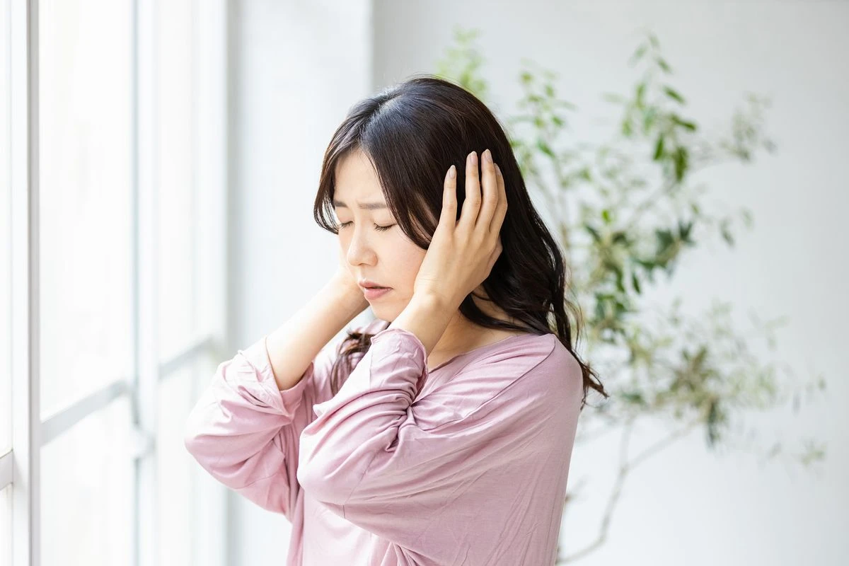 頭をおさえる女性のイメージ