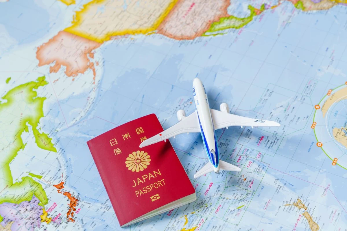 世界地図と飛行機のおもちゃとパスポートのイメージ