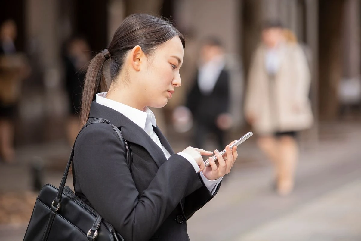 スマホを見る新卒社員のイメージ