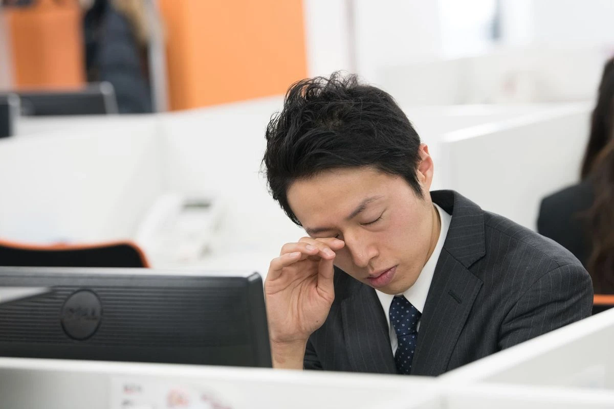 眠そうな男性社員のイメージ