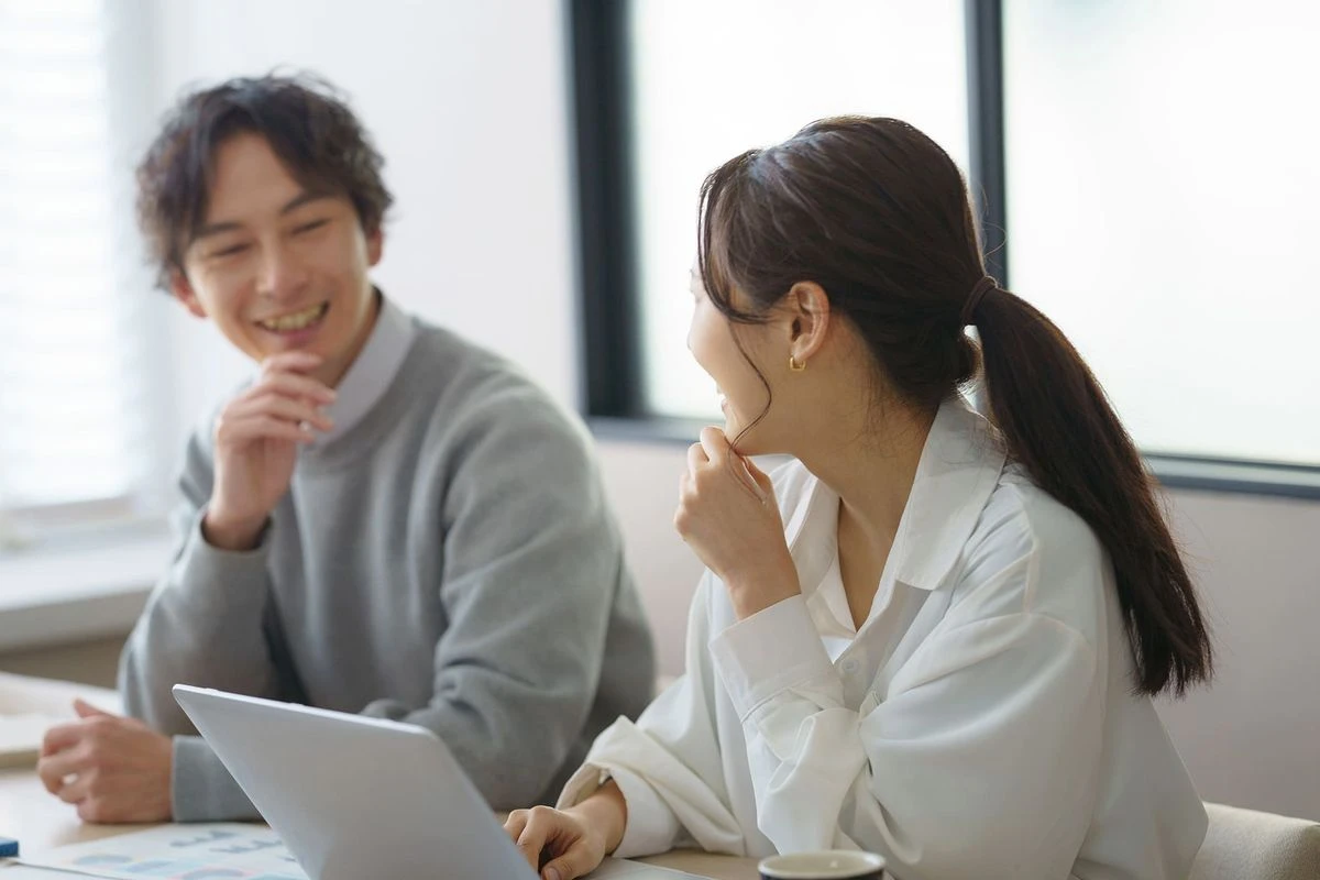 職場で仲良く話す男女のイメージ