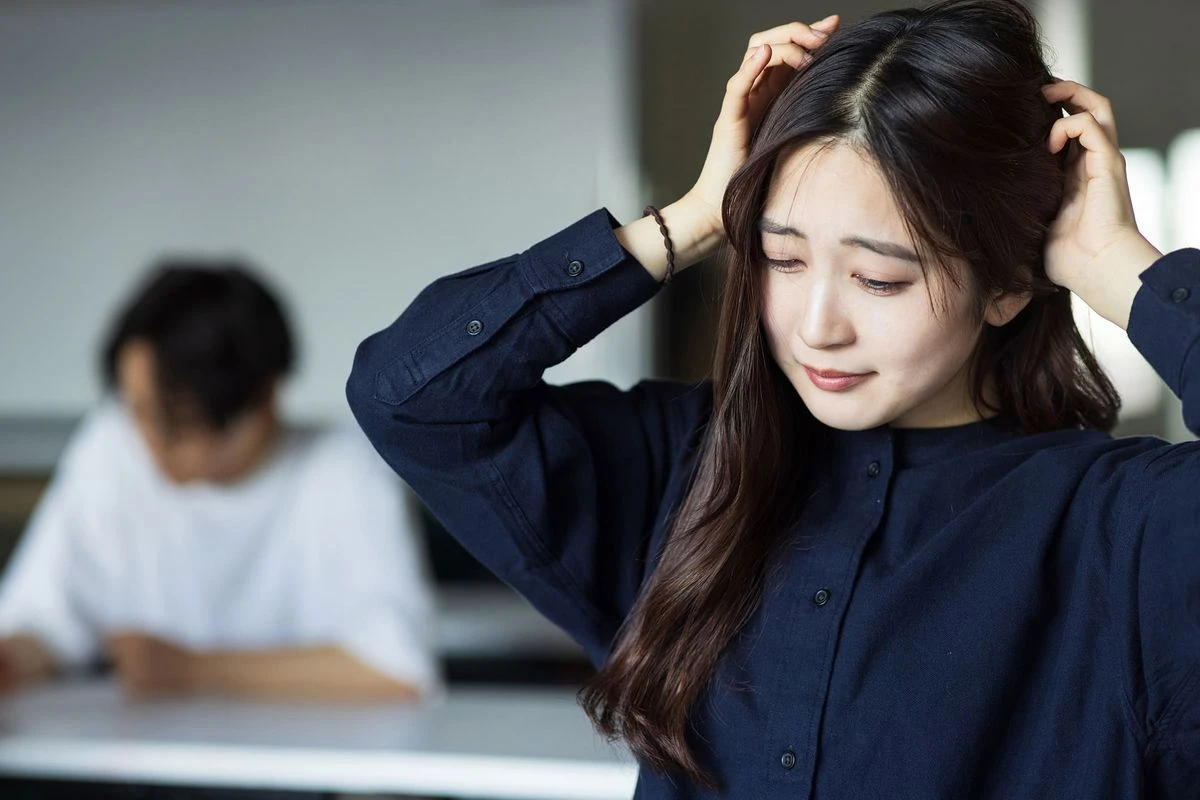 頭をおさえる女性のイメージ