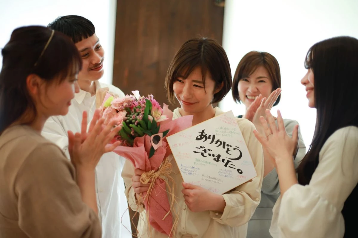 花束と色紙を持っている女性