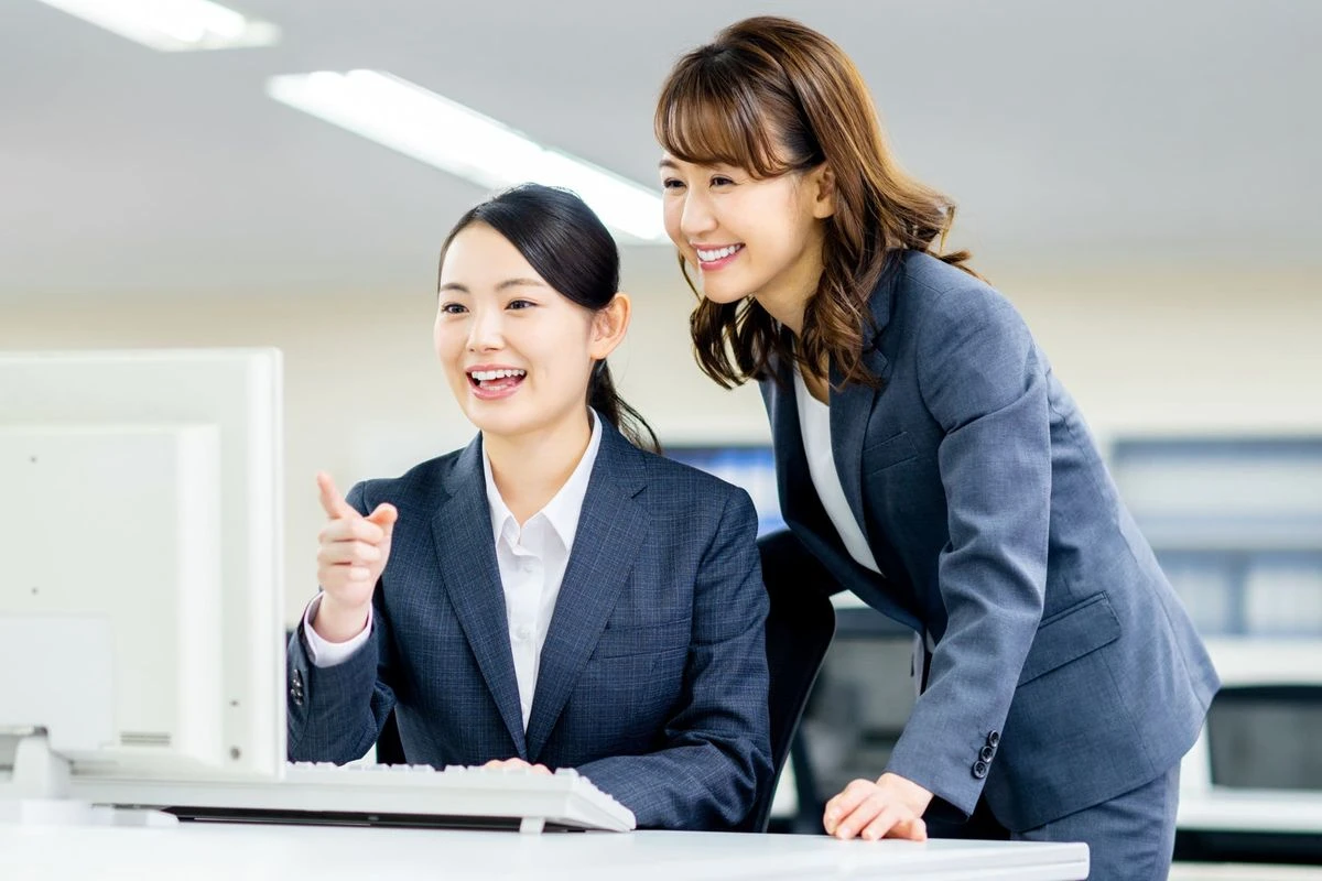 先輩社員が新入社員に指導をしているイメージ