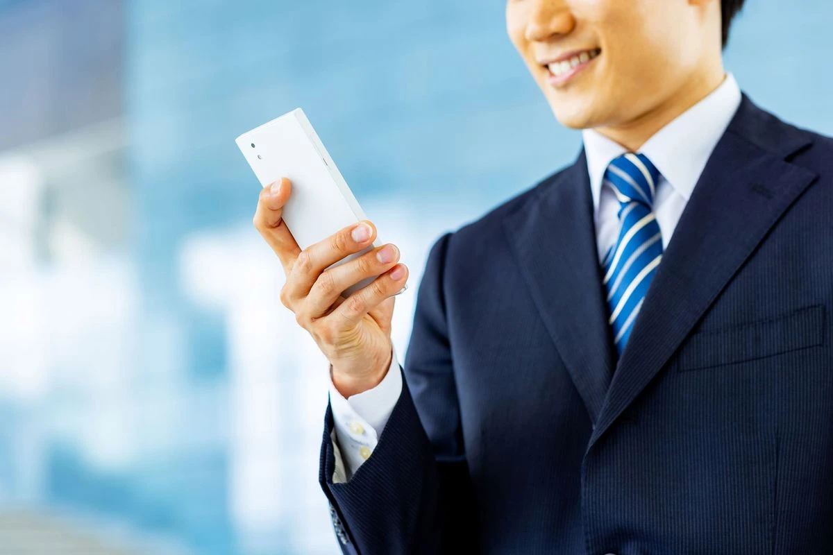 企業からのお礼メールをスマホで見ている学生のイメージ