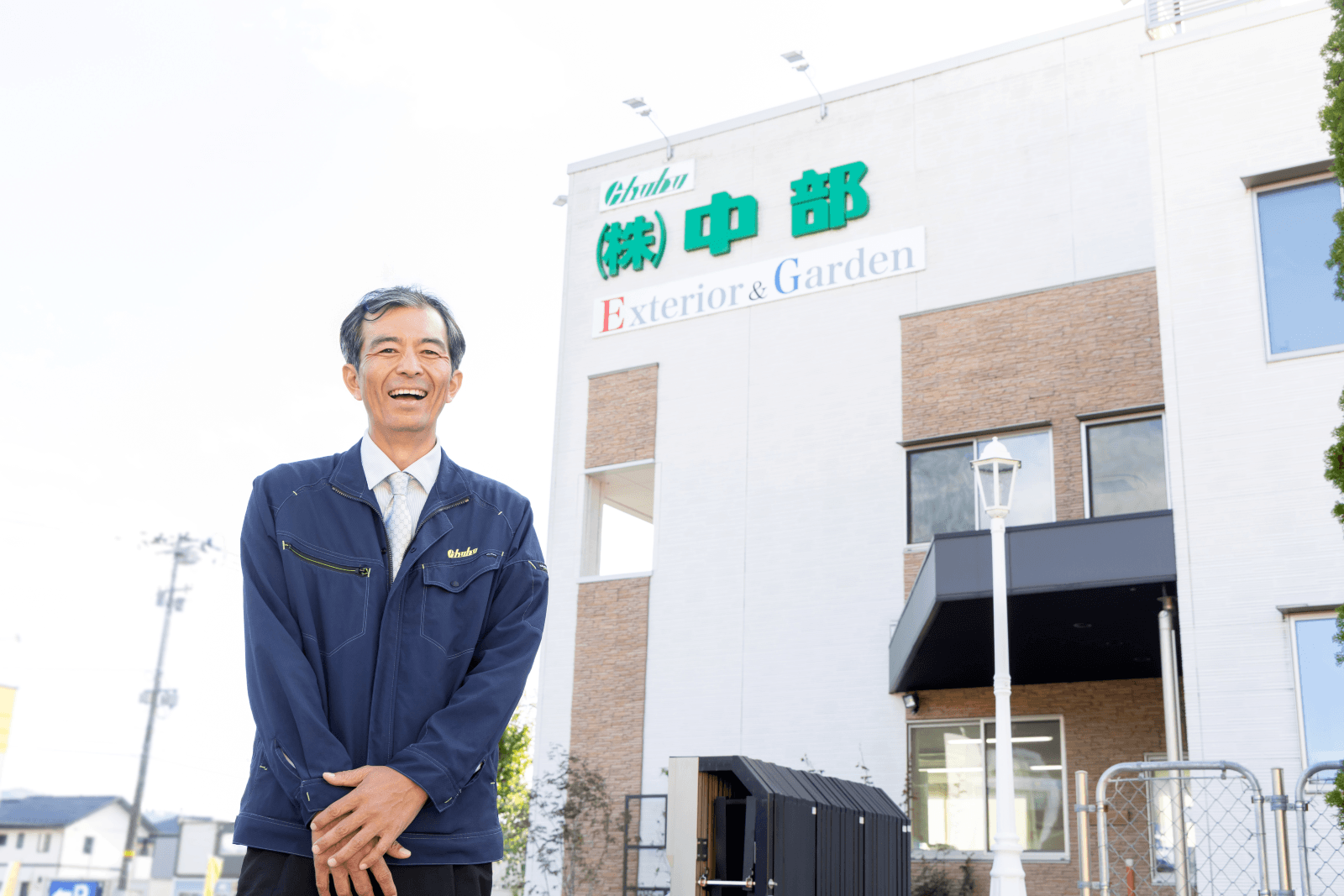 株式会社中部様メインビジュアル社屋前の元木氏