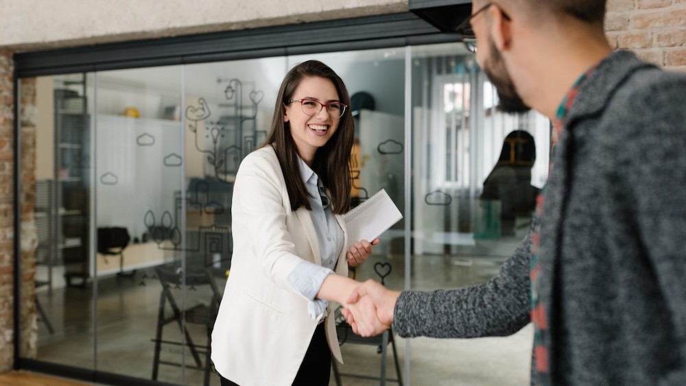 Two people shaking hands in an office environment