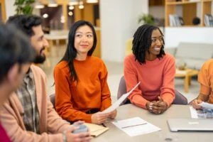 A group of coworkers in an office setting having a casual discussion.