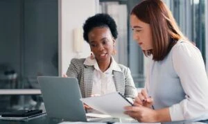 Two women working together on a laptop