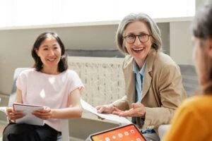 Smiling businesswoman leads a team meeting in a vibrant office.