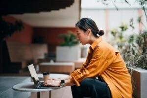 Una mujer trabajando afuera en una laptop