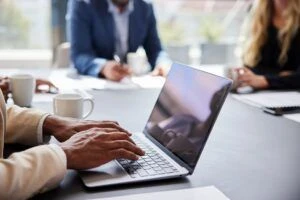 Las manos de una persona tecleando en una laptop.