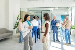 Varias personas conversando o esperando en un lobby.