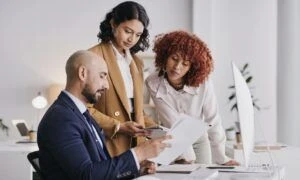 Tres personas analizando información.