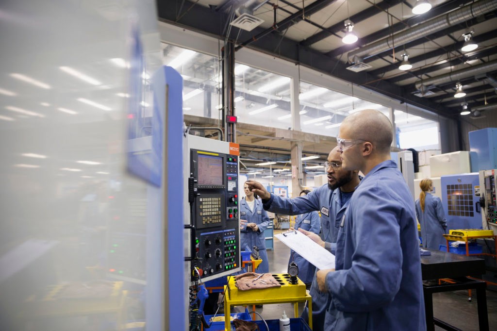Workers at control panel in factory