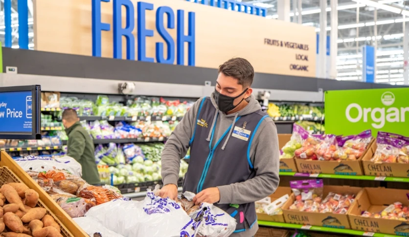A Walmart employee unloading produce in the store