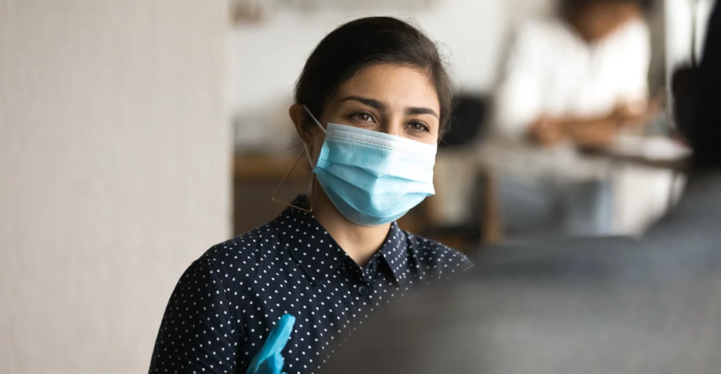 Female wearing a mask talking to a person
