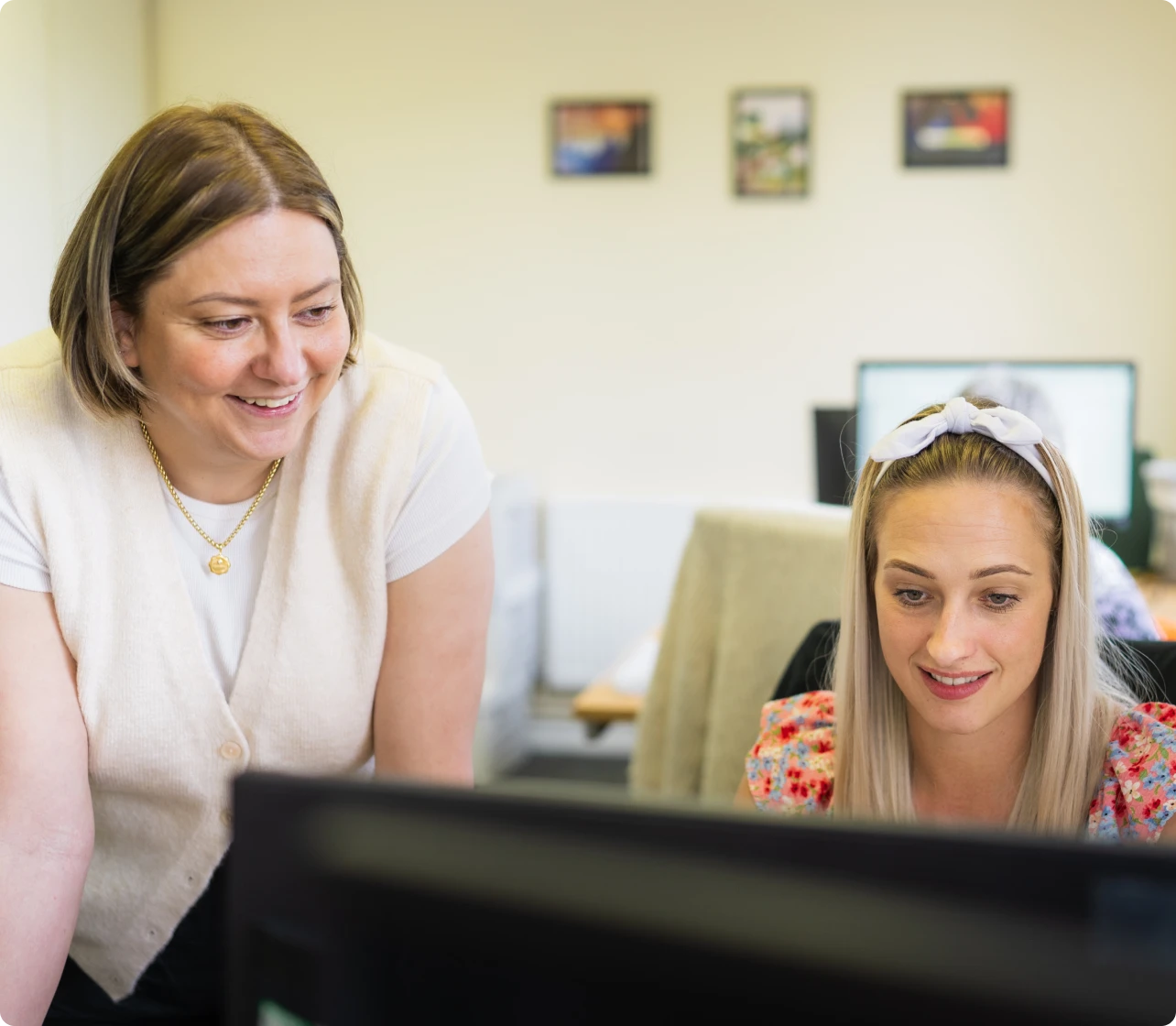 Two women looking at a computer monitor