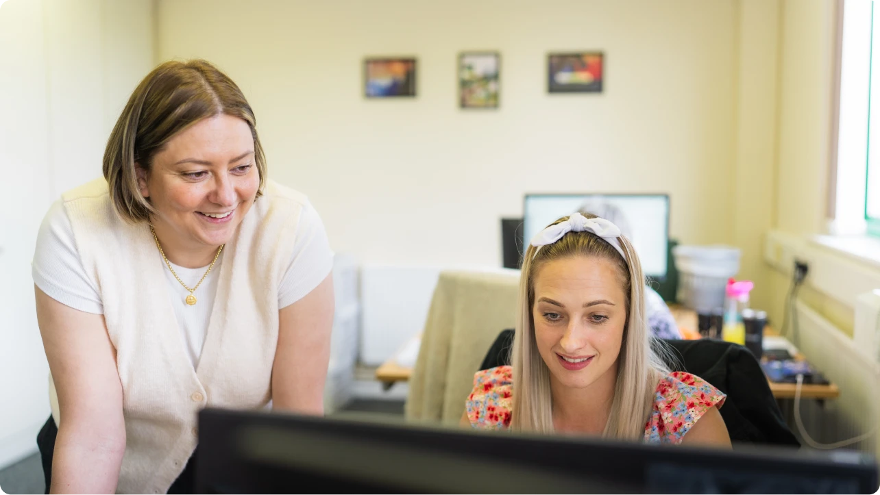 Two women looking at a computer monitor