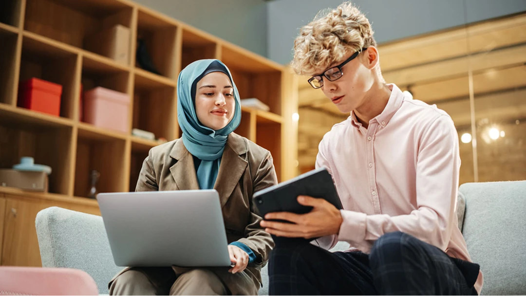 Zwei Mitglieder des Personalteams nutzen einen Laptop bzw. ein Tablet, um Jobsuchende über Premium-Stellenanzeigen Plus zu kontaktieren.