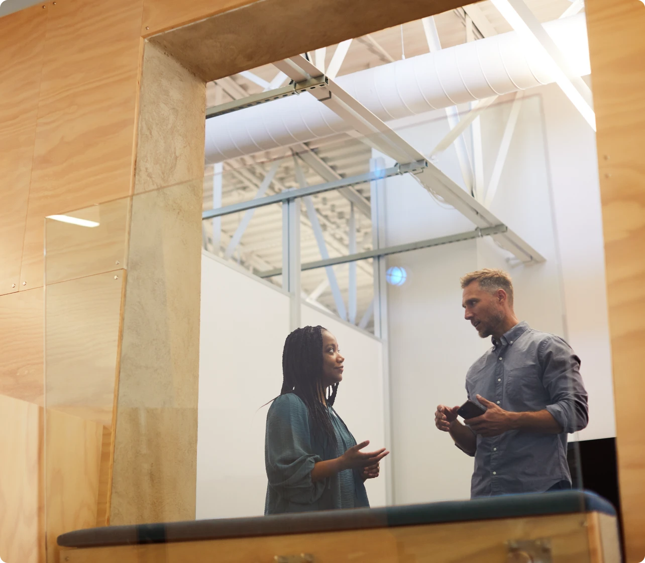 Two people having a conversation in an office environment
