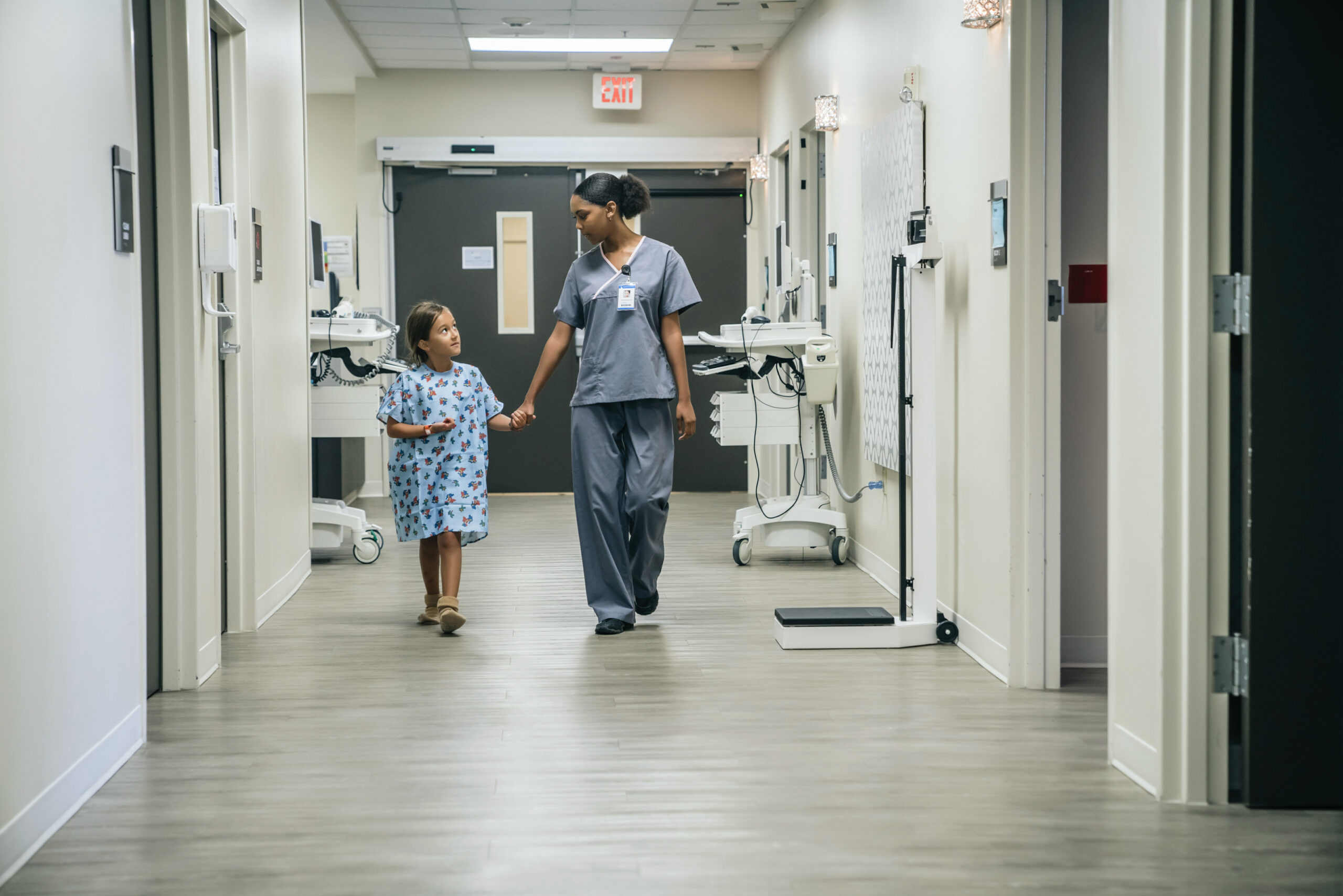 Medical professional holding hands with a child in hospital
