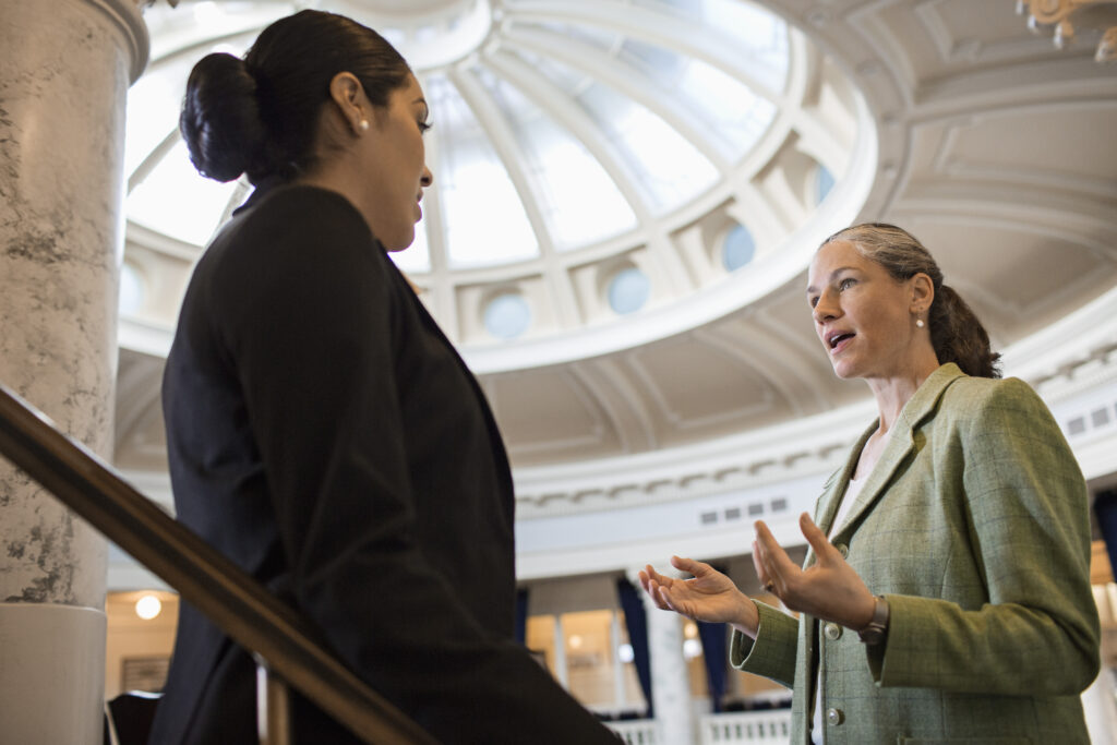 Two people talking in the rotunda of a capital building