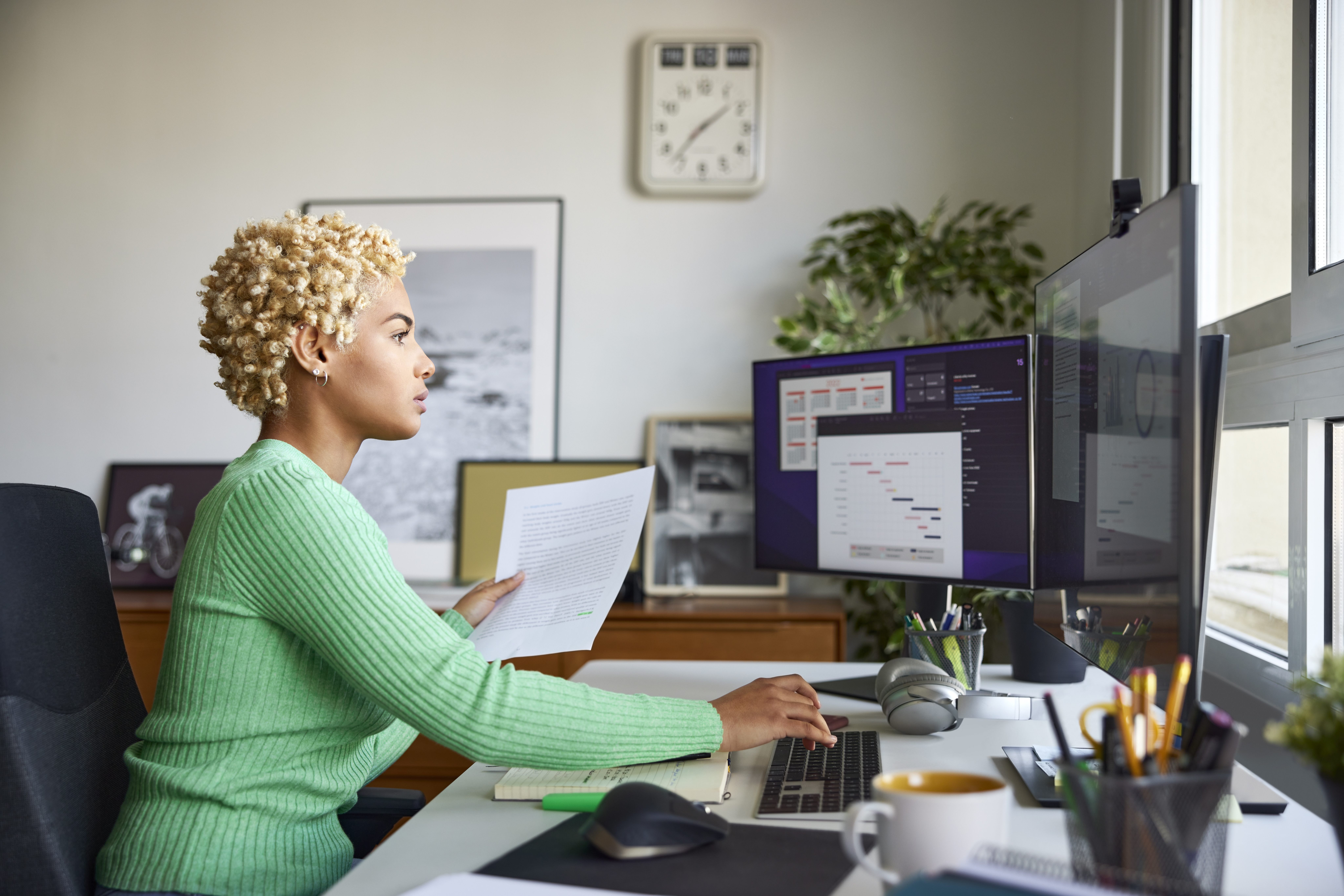 Side view of Person working at desk looking at their computer in the office