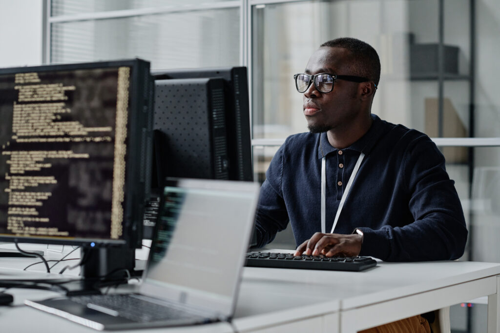 Developer working with new program at desk in front of computer in the office