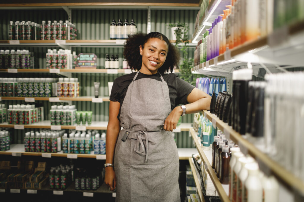 Smiling retail employee wearing an apron in the store