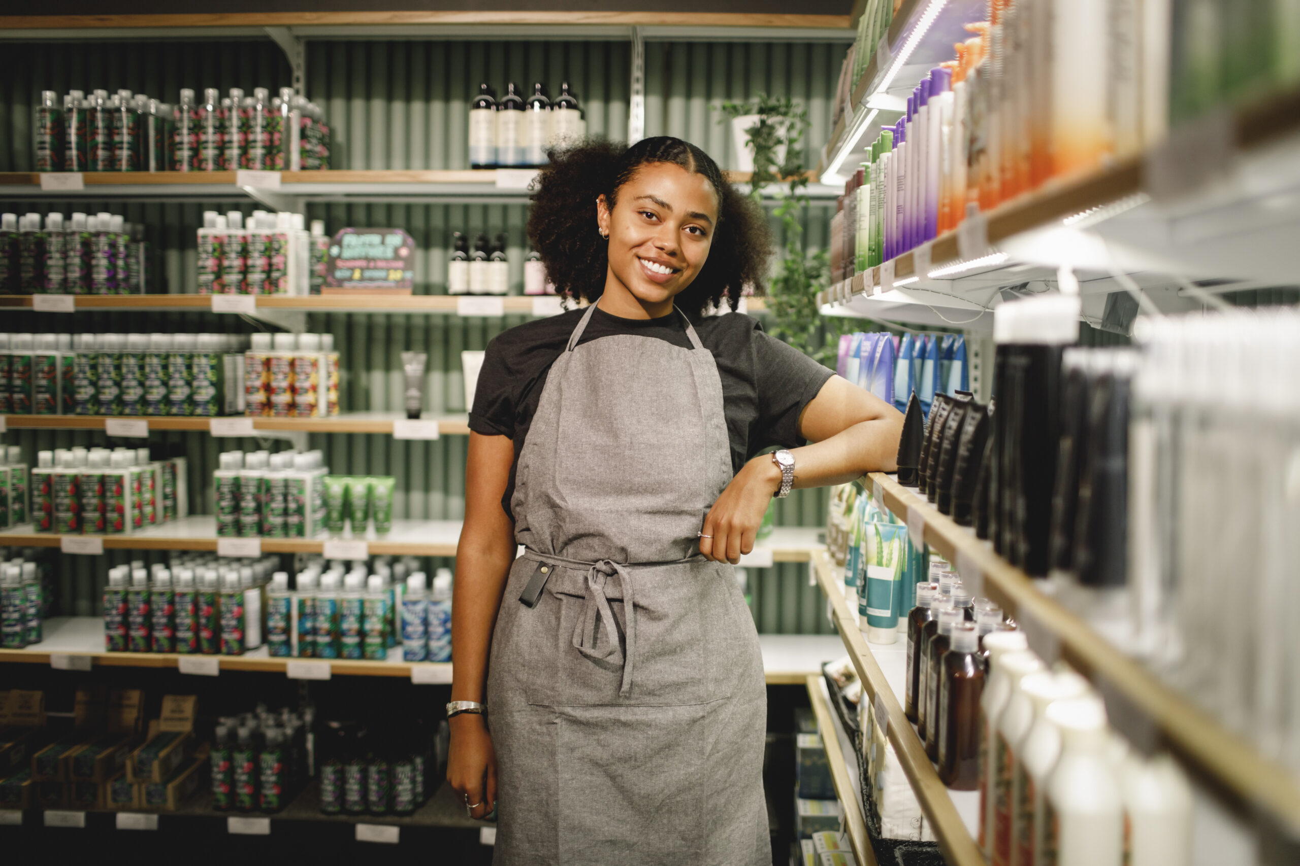 Smiling retail employee wearing an apron in store