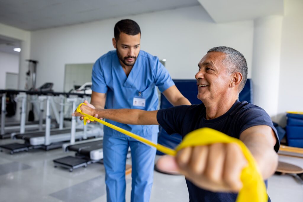 Person doing physical therapy exercises using a stretch band with the assistance of their therapist