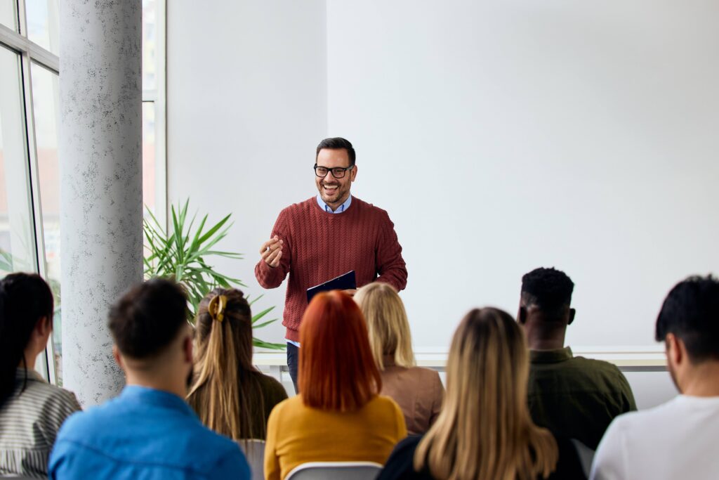 Speaker delivering a motivating training session to a group of diverse employees.