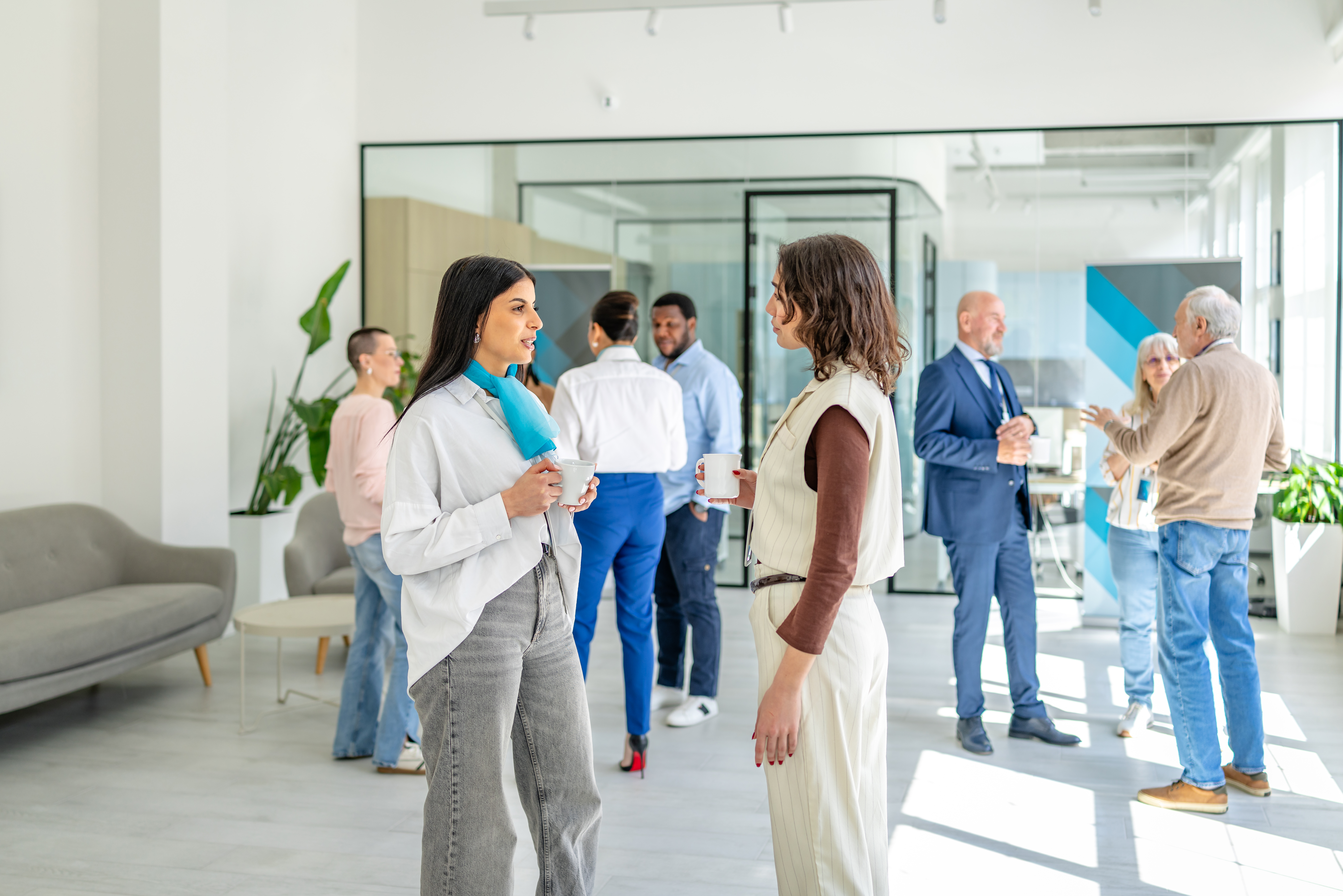 Coworkers gather in a sunlit modern office.