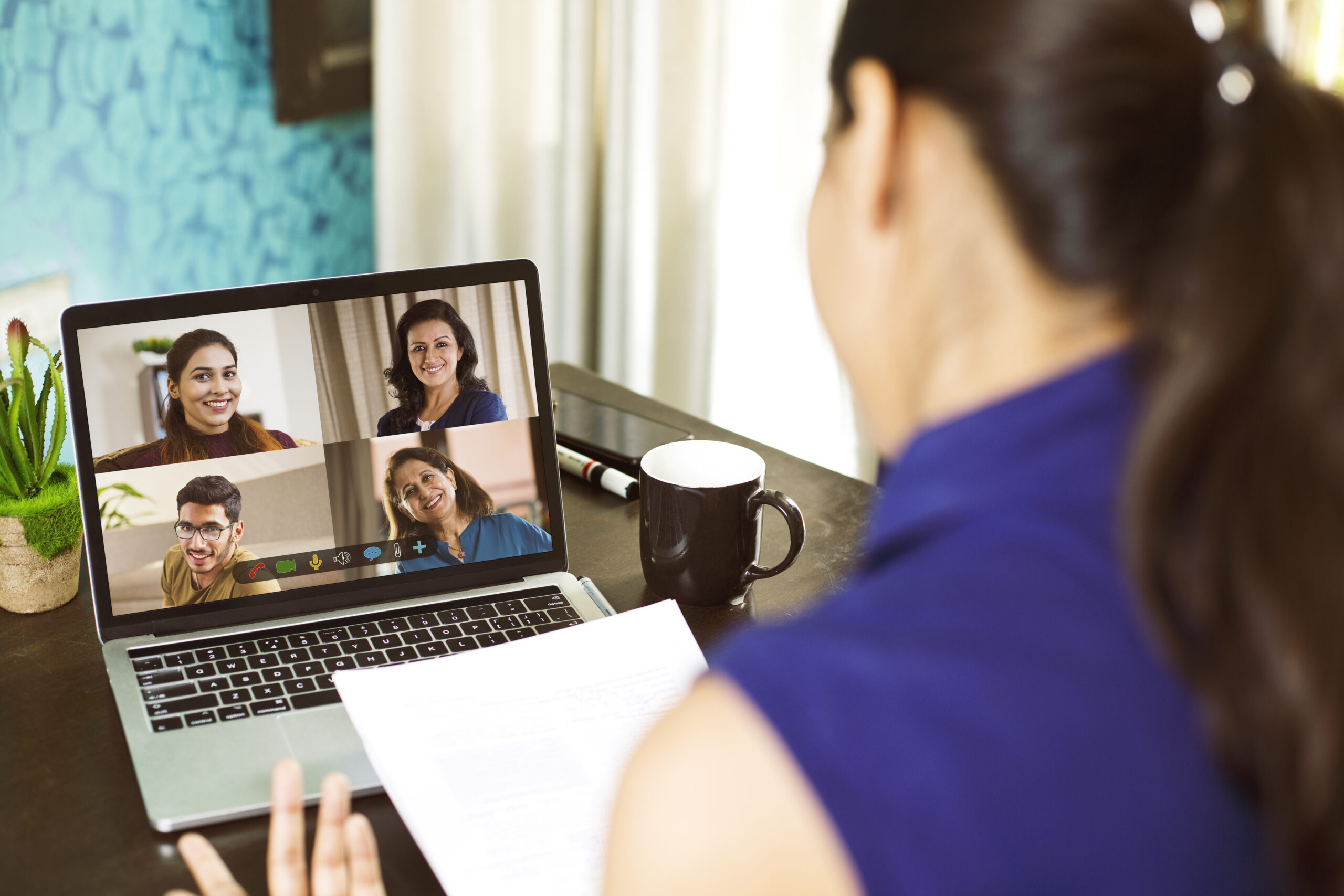Person attending business video call meeting using laptop at home