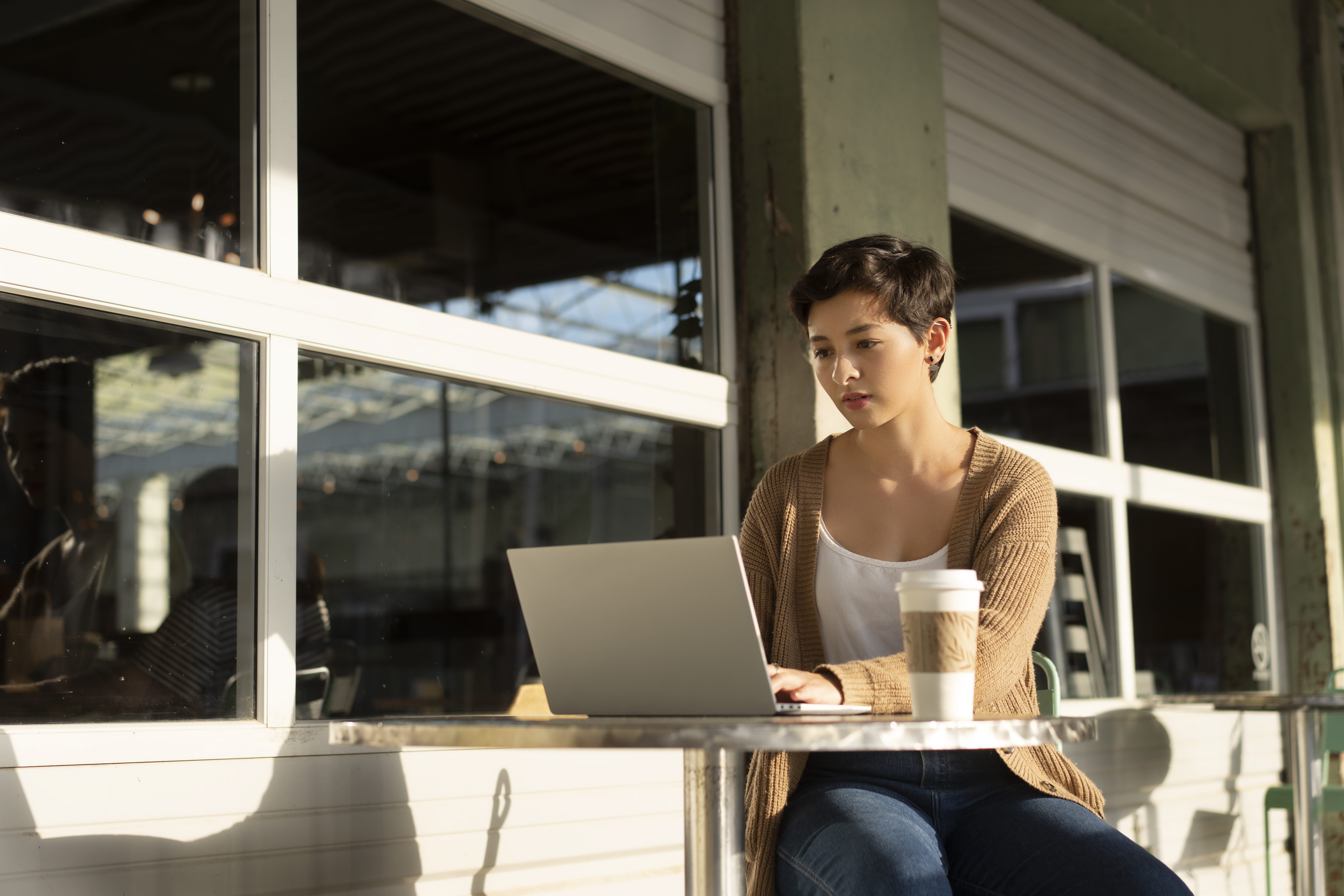 Person working on a laptop outside a cafe