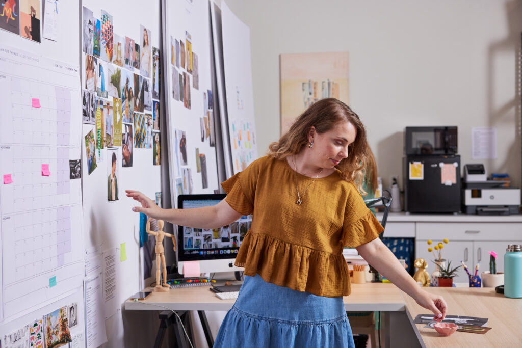 Person pinning pictures to the wall in the office