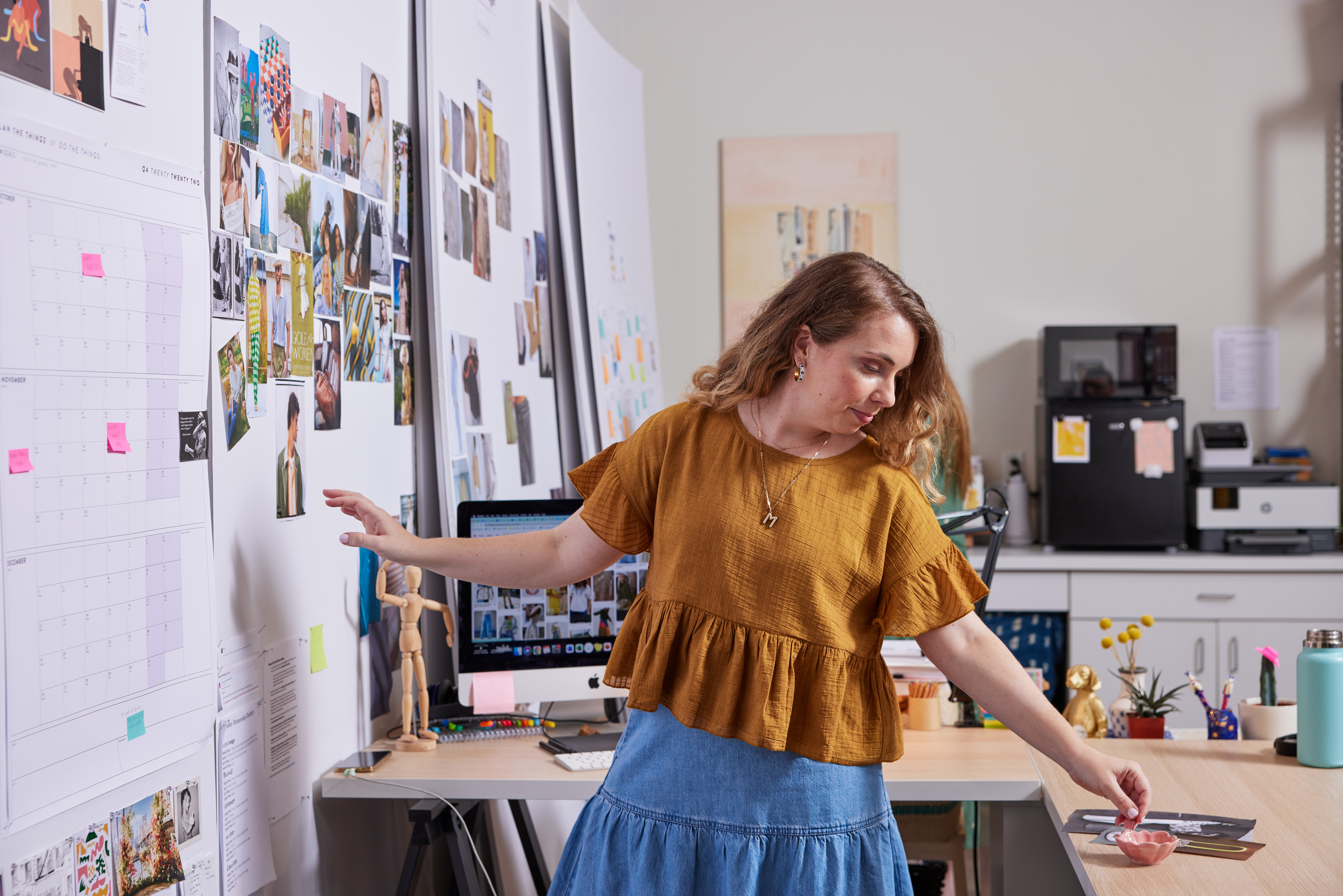 Person pinning pictures to the wall in the office
