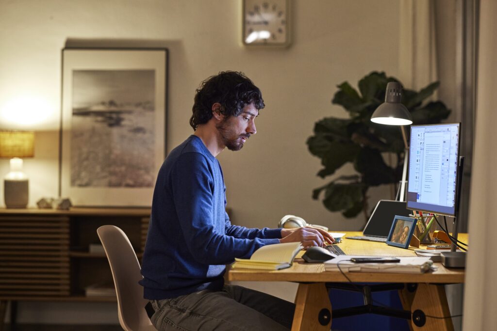 Person using computer at home, working late, sitting at a table.