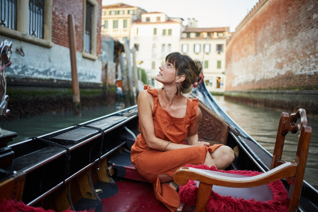 Young person riding in a gondola in a Venice canal
