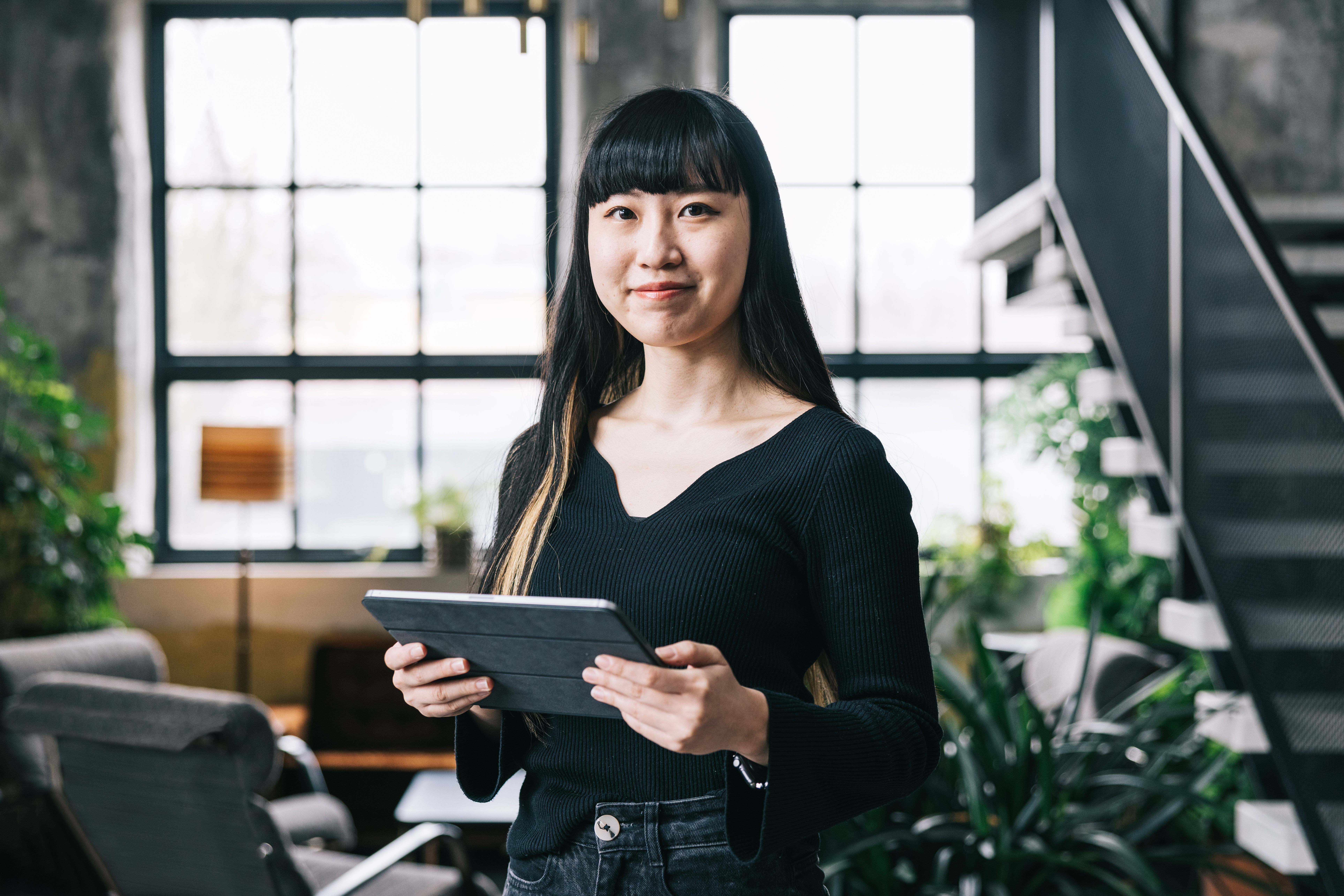 Portrait of smiling employee holding digital tablet in the office