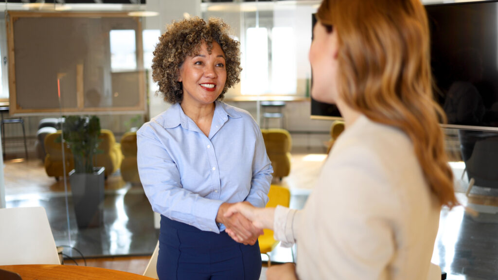 Deux collègues souriants se serrant la main au bureau