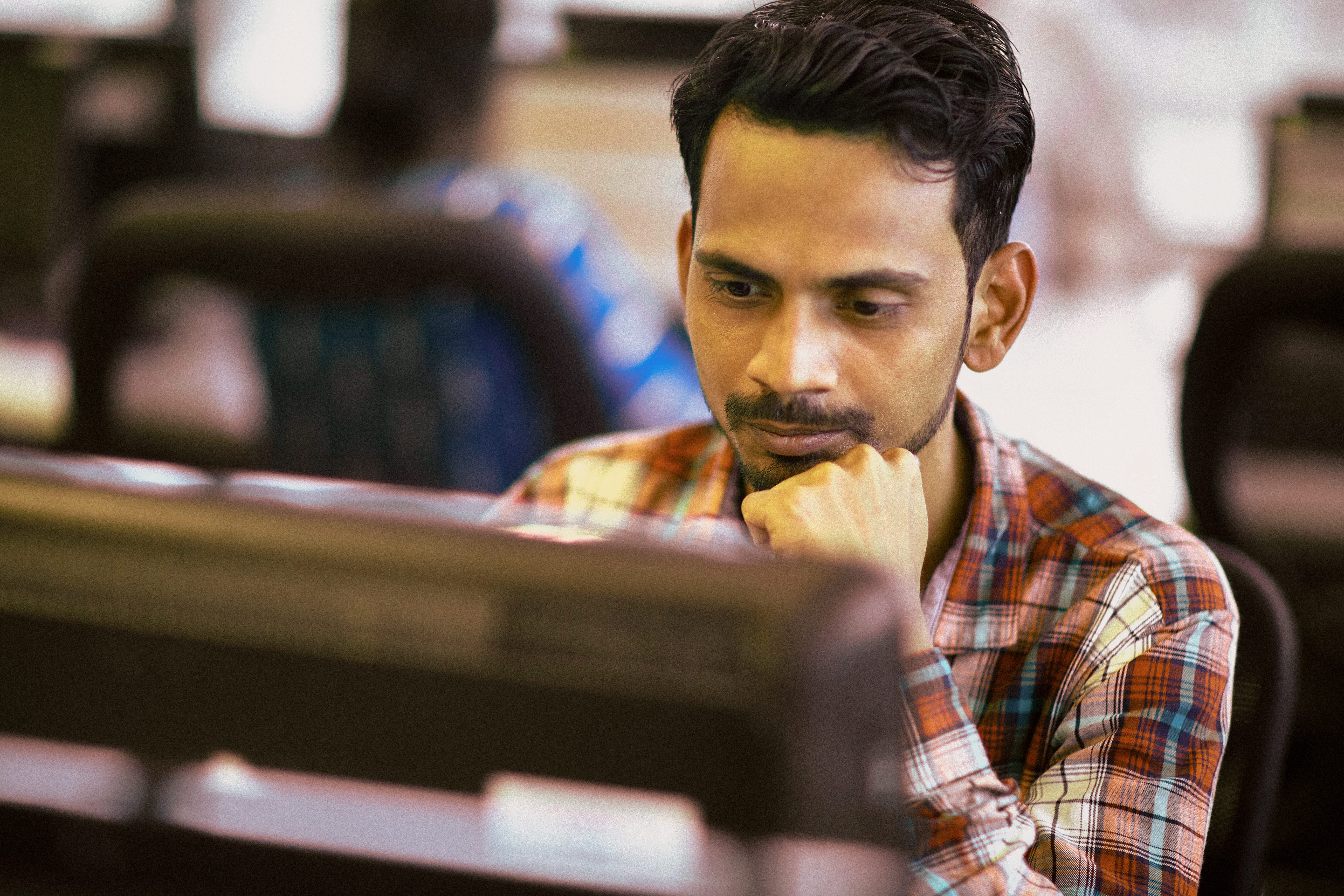 Person im Büro schaut auf Computerbildschirm