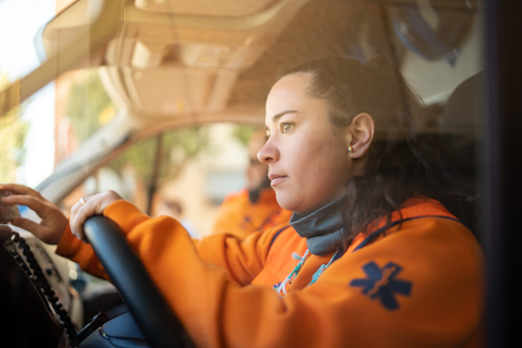 Sanitäter*in in Uniform fährt Krankenwagen