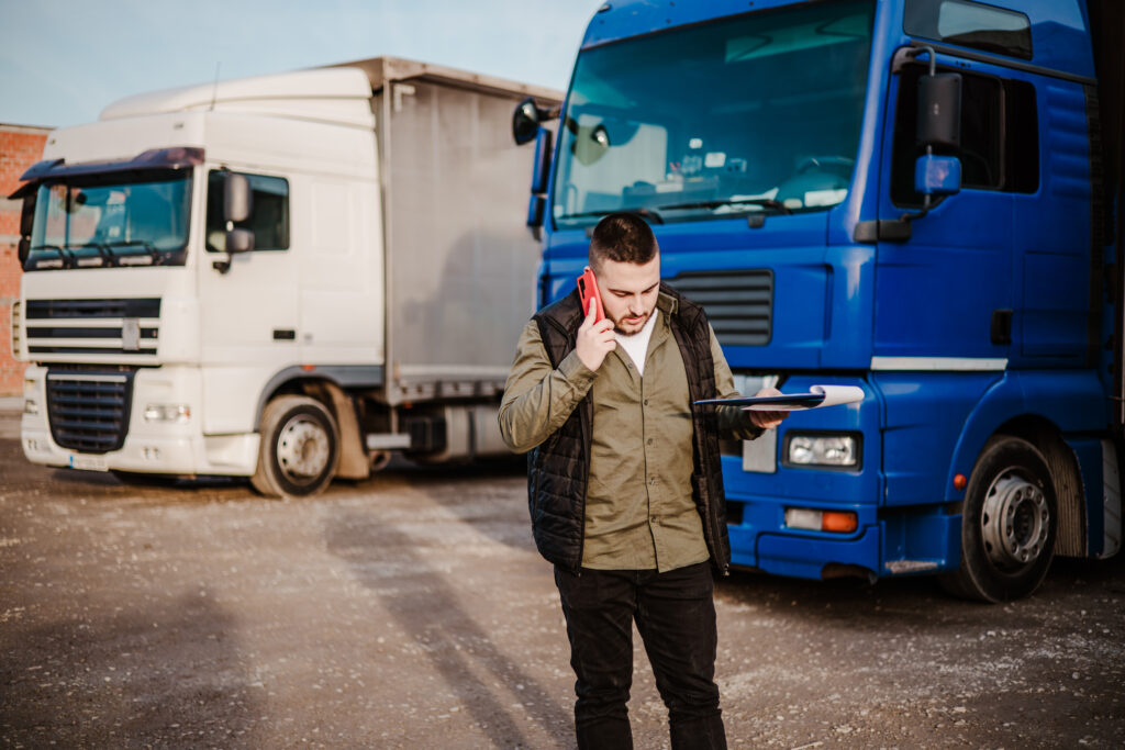 Berufskraftfahrer telefoniert vor zwei LKWs