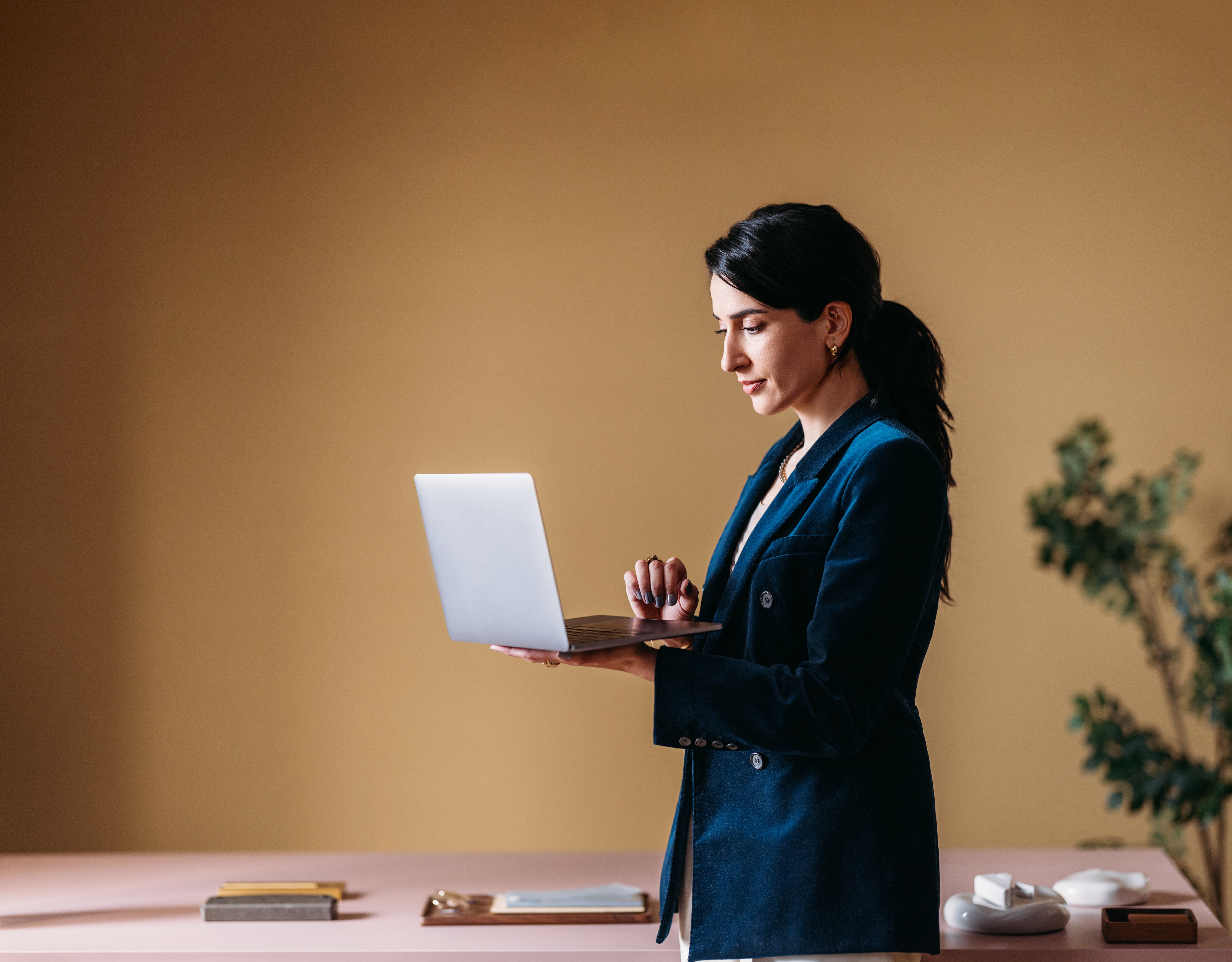 Person standing with laptop open looking at screen
